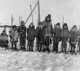 Omie Cochran in Nome with children holding skis